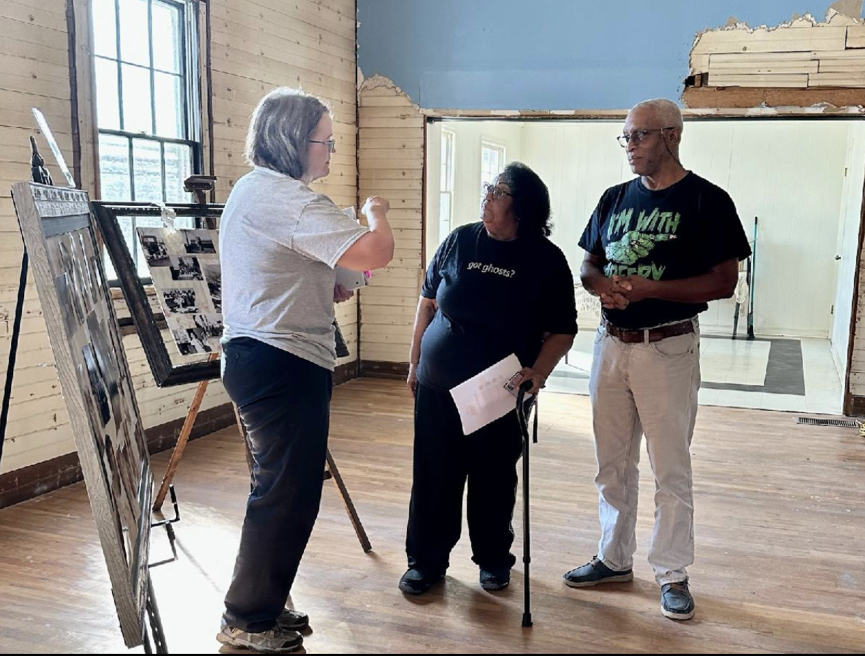 Jamie Lovett shares historic photographs with Tony and Shirley Noel while discussing the history of Woolsey by C Griffin © 2023
